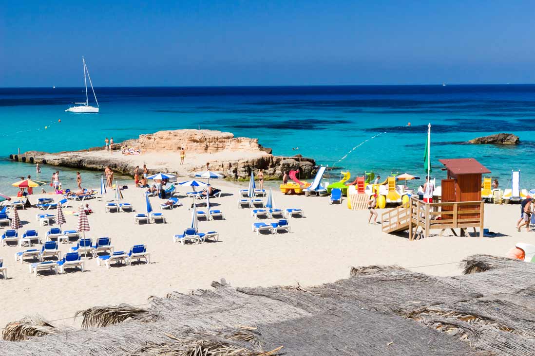 tumbonas en la arena del Cala Tarida de Sant Josep de la Talia en la Isla de Ibiza