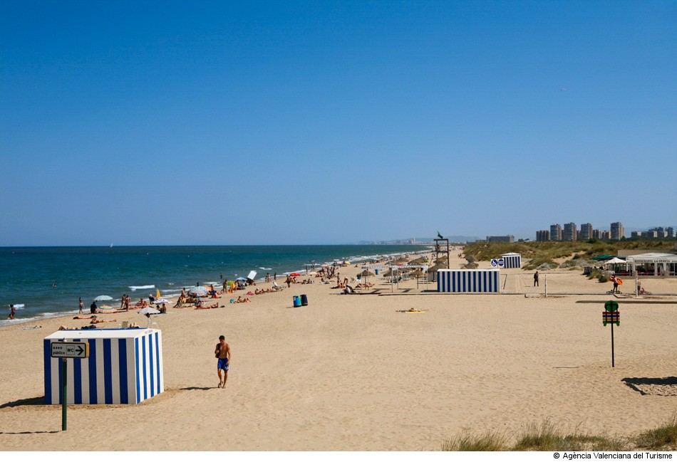 bañistas disfrutando del sol y de la playa en la playa el Saler de Valencia